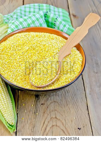 Corn grits with cob and spoon on board