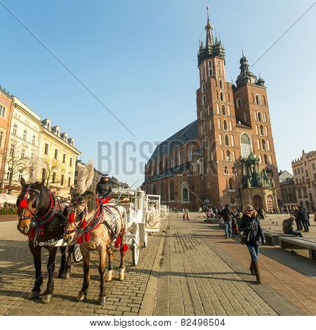 KRAKOW, POLAND - FEB 7, 2015: St. Mary's Church in historical center of Krakow on Main Square - dates to the 13th century, and at roughly 40,000 m it is the largest medieval town square in Europe.