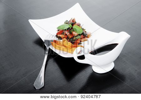 vegetable salad : cherry tomatoes and basil with sweet baked potato served on white plate with sauce boat full blask soy sauce on wood