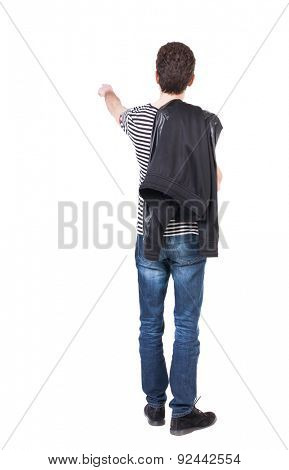 Back view of pointing man in winter jacket  looking up.   Standing young guy in parka.  Putting his jacket on his right shoulder guy shows finger of the other hand.