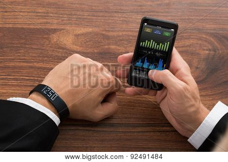 Businessman Checking Fitness Stats On Cellphone