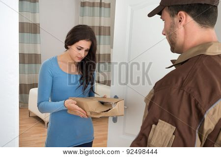 Woman Holding Damaged Package From Delivery Man