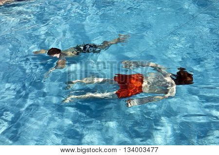 Happy Children Diving In The Pool