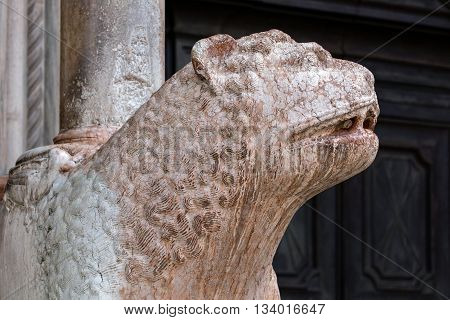 Medieval statue of a lion in Verona marble holding one of the columns of the Cremona's Cathedral narthex