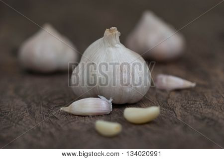 Garlic.Close up of garlic bulb and cloves on wooden surface.