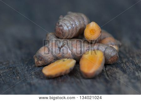 Group of turmeric roots on wood background