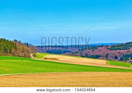 Landscape With Fields And A Village With Hills At The Horizon