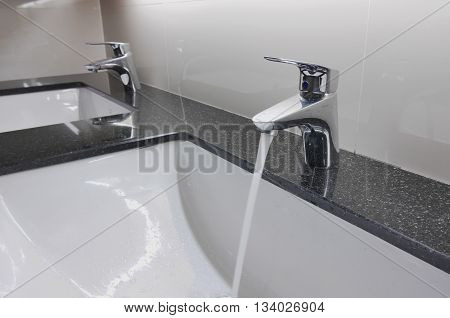 White Washbasins And Faucet On Granite Counter With Water Drop