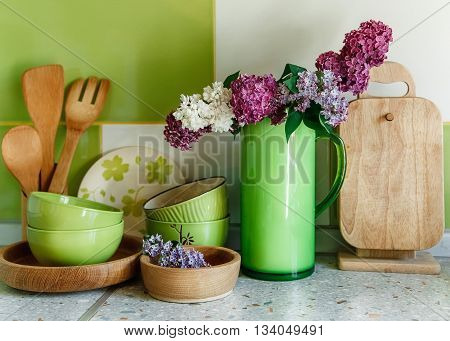 Kitchen  Ceramic and Wooden Tableware,Bouquet of Lilac in the Green Plastic Pitcher.