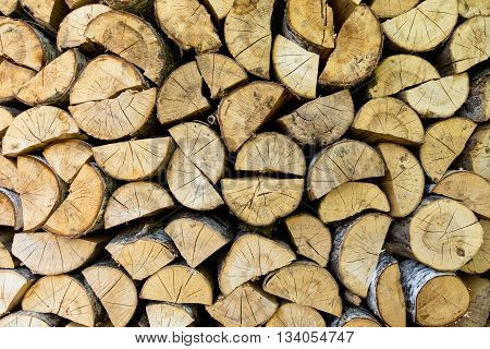 Firewood texture background. Chopped birch firewood, stacked in woodshed and snowbound