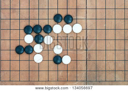 top view black and white stones playing with basic joseki in conner on go game board traditional chinese strategy board game sport hobby and recreation