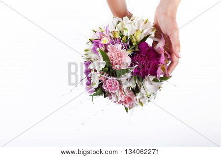 Hands holding a pastel bouquet from pink and purple gillyflowers and alstroemeria