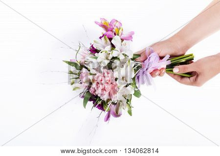 Hands holding a pink bouquet from gillyflowers and alstroemeria
