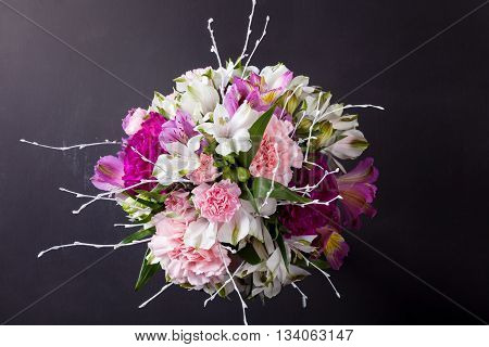 Pink bouquet from gillyflowers and white alstroemeria on blackboard top view