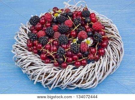 berry assortment on blue wooden background. Ecoproduct.