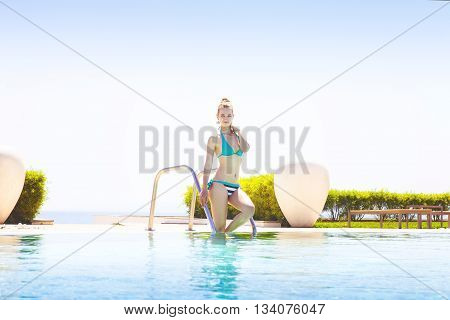 Pretty blond woman enjoying a swimming pool
