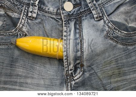 banana fruit in condom inside jeans pants contraceptive concept