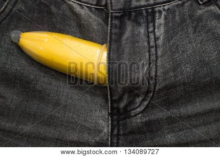 banana fruit in condom inside jeans pants contraceptive concept