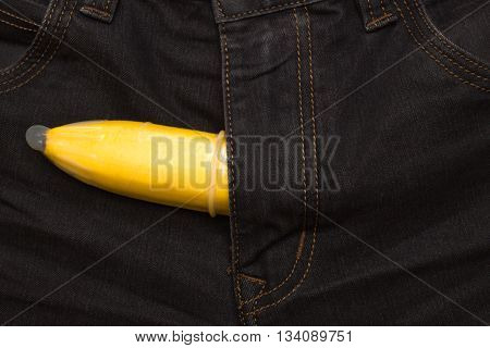 banana fruit in condom inside jeans pants contraceptive concept