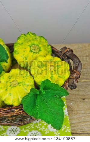 Scalloped Squash Pattypan on bamboo basket on a wooden background. Eco vegetables.