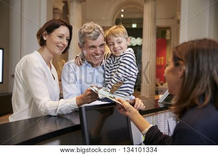 Family Buying Entry Tickets To Museum From Reception