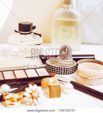 Jewelry table with lot of girl stuff on it, little mess in cosmetic brushes, real woman interior concept