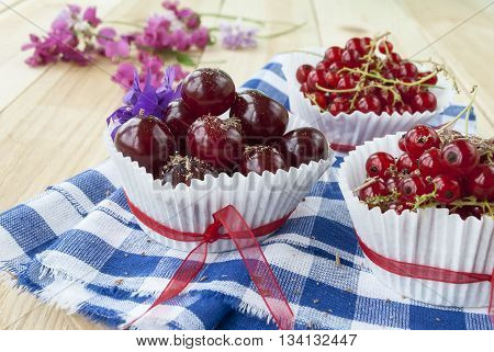 fresh cherries and currants with chocolate shavings on a wooden backgroundred berries closeup.