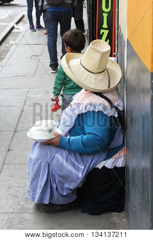 Cajamarca Peru - June 11 2016: Andean woman in traditional dress sells cheese on the street in Cajamarca Peru on June 11 2016