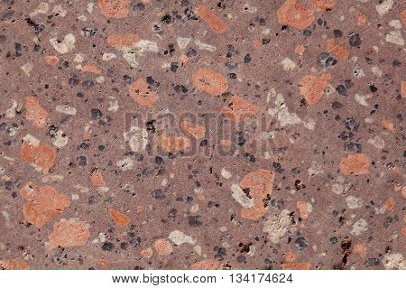 Surface of a porphyry rhyolite rock from central Europe Saxony-Anhalt. The rock contains fragments of feldspars quartz and amphibole minerals in a fine grained matrix.