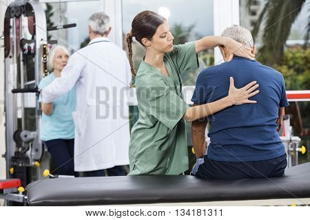 Physiotherapist Massaging Senior Man's Back