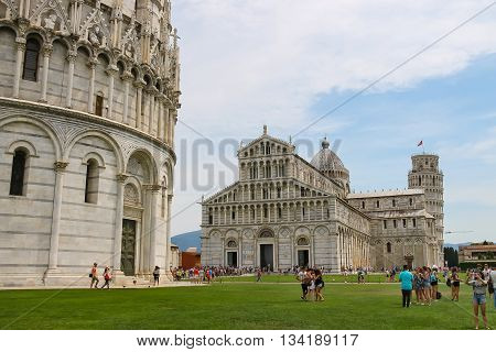 Pisa Italy - June 29 2015: Tourists walking on Piazza del Duomo in historic centre. Province Pisa Tuscany region of Italy