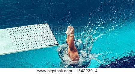 Female diver jumping from platform high angle view