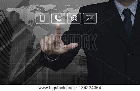 Businessman pressing telephone mobile phone at and email buttons over map and city tower Customer support concept Elements of this image furnished by NASA