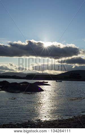 boats in a quiet bay near kenmare on the wild atlantic way ireland with a cold sunset