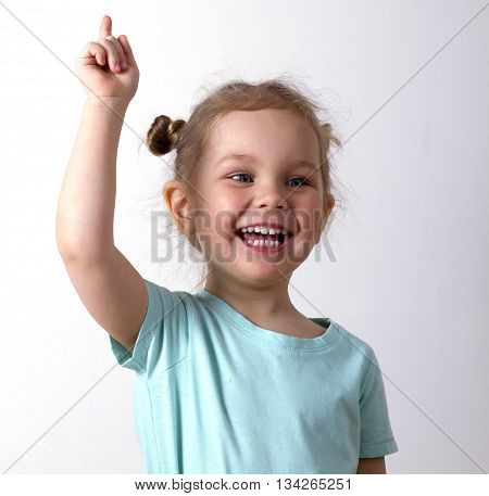 little girl in a blue t-shirt raised her hands up and smiling blonde