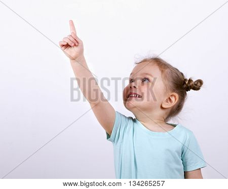 little girl in a blue t-shirt raised her hand up. calls for attention