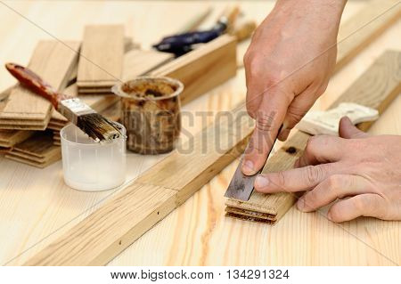 Carpenter hands at work with chisel closeup