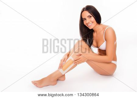 Happy Smiling Woman Using Beewax Stripe For Shaving Legs