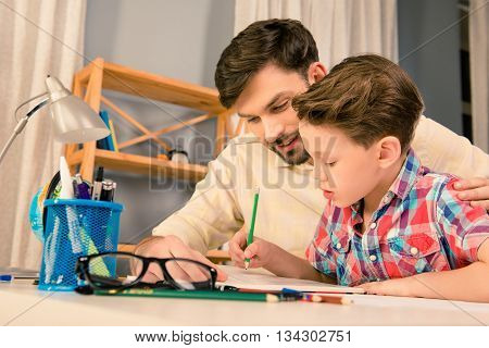 Happy Family. Father And Son Doing Homework Together