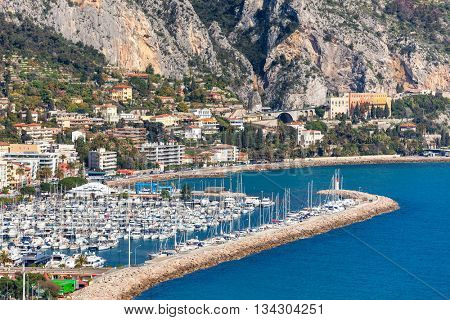 View of marina with yachts along shoreline of Menton - small town on French Riviera.
