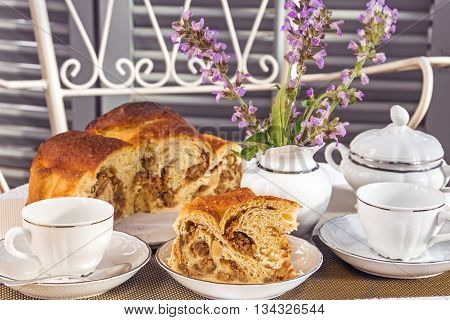 Typical italian flavorous farmhouse cake La Gubana with sophisticated stuffing (hazelnuts fruit chocolate walnut raisins honey etc.) on the table covered for tea time. Traditionally bake for Christmas and Easter.