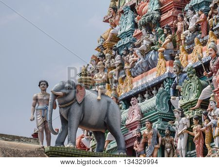 Chettinad India - October 17 2013:Detail of the Shiva temple gopuram at Kottaiyur shows Lord Shiva as supreme teacher and elephant walking away. Plenty of colorful statues.