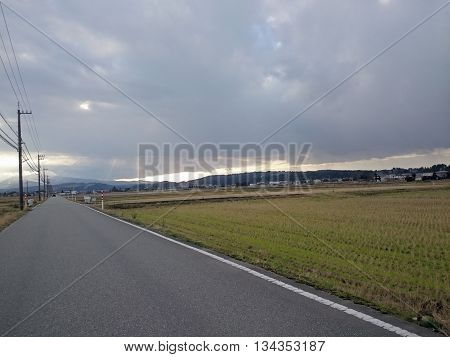 Long raod covered with dark rainy clouds