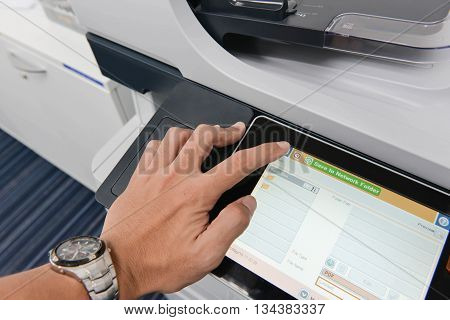 Human hand is using the printer for document copy