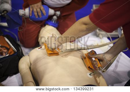 Defibrillation. First aid. Paramedic demonstrate defibrillation on dummy.