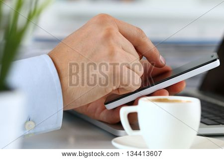 Close up view of businessman hands holding smart phone. Mobile applications playing games social media organizing work online banking or purchase concept.