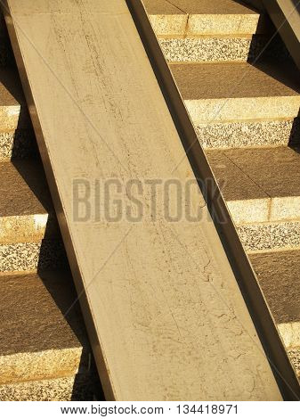 Detail of concrete stirway with metallic ramp for wheelchairs and pushchairs