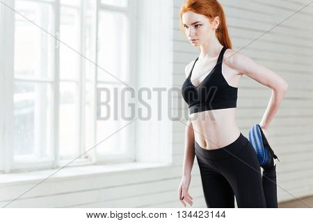 Young beautiful fitness woman doing stretching exercices at the gym
