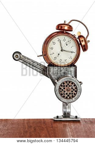 Bronze vintage alarm clock in meat grinder.Toned image.