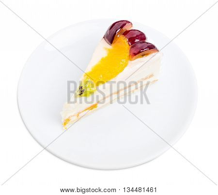 Creamy yougurt mousse cake with fruits on top. Isolated on a white background.